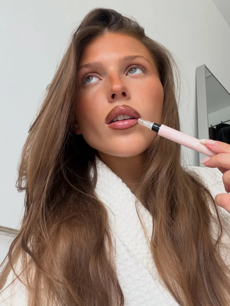Woman applying Smooche lip gloss