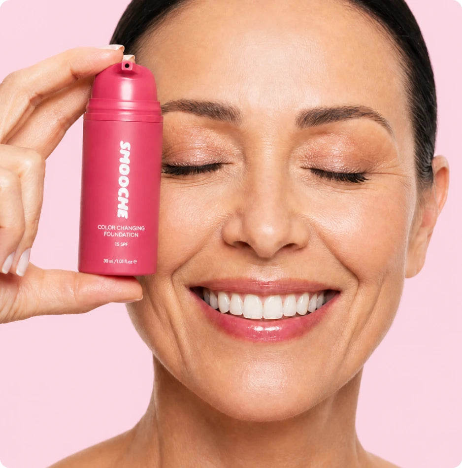 Woman smiling while holding Smooche foundation