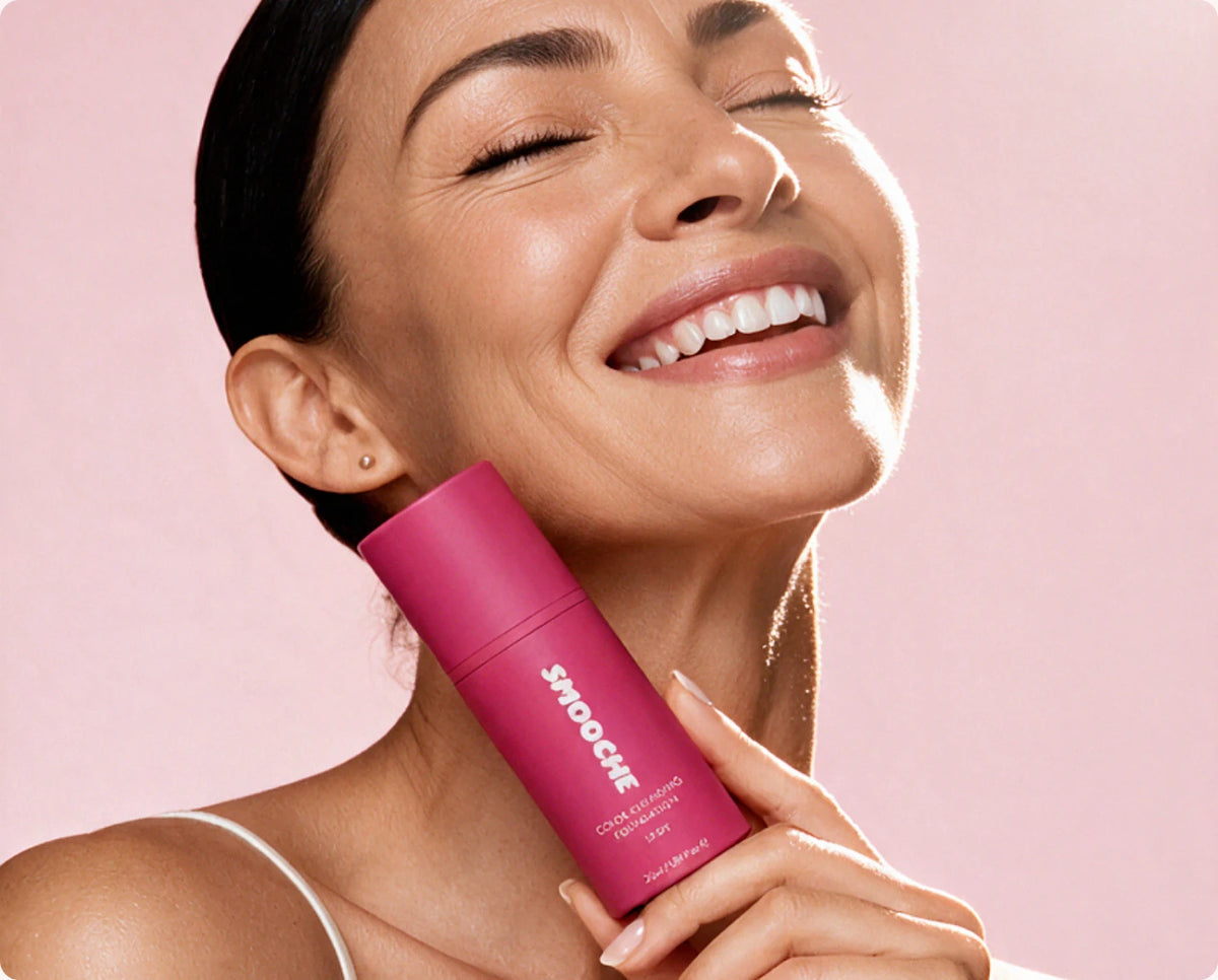 Woman laughing while holding Smooche foundation to her chin
